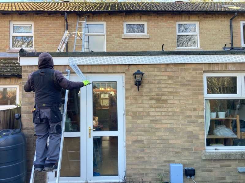 Roofer replacing guttering in Cambridge